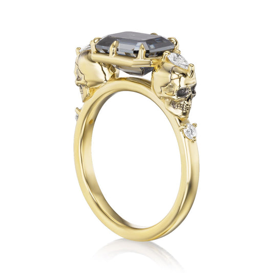 ::color_yellow ::| 2.5ctw emerald cut grey moissanite engagement ring Juliet Skull memento mori yellow gold diamond accents standing 3/4 view
