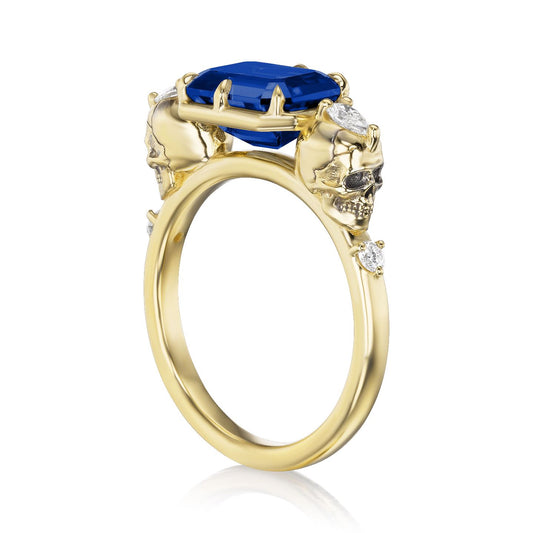 ::color_yellow ::|3.1ctw radiant cut lab-grown blue sapphire engagement ring Juliet Skull memento mori yellow gold diamond accents standing 3/4 view