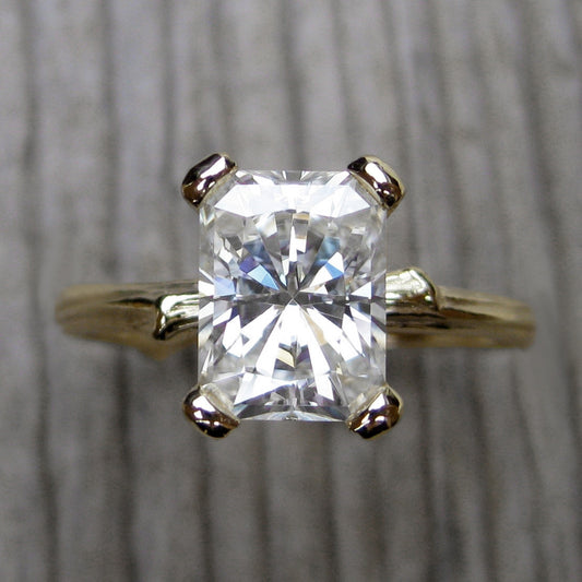 yellow gold twig solitaire engagement ring with a Forever One radiant cut moissanite