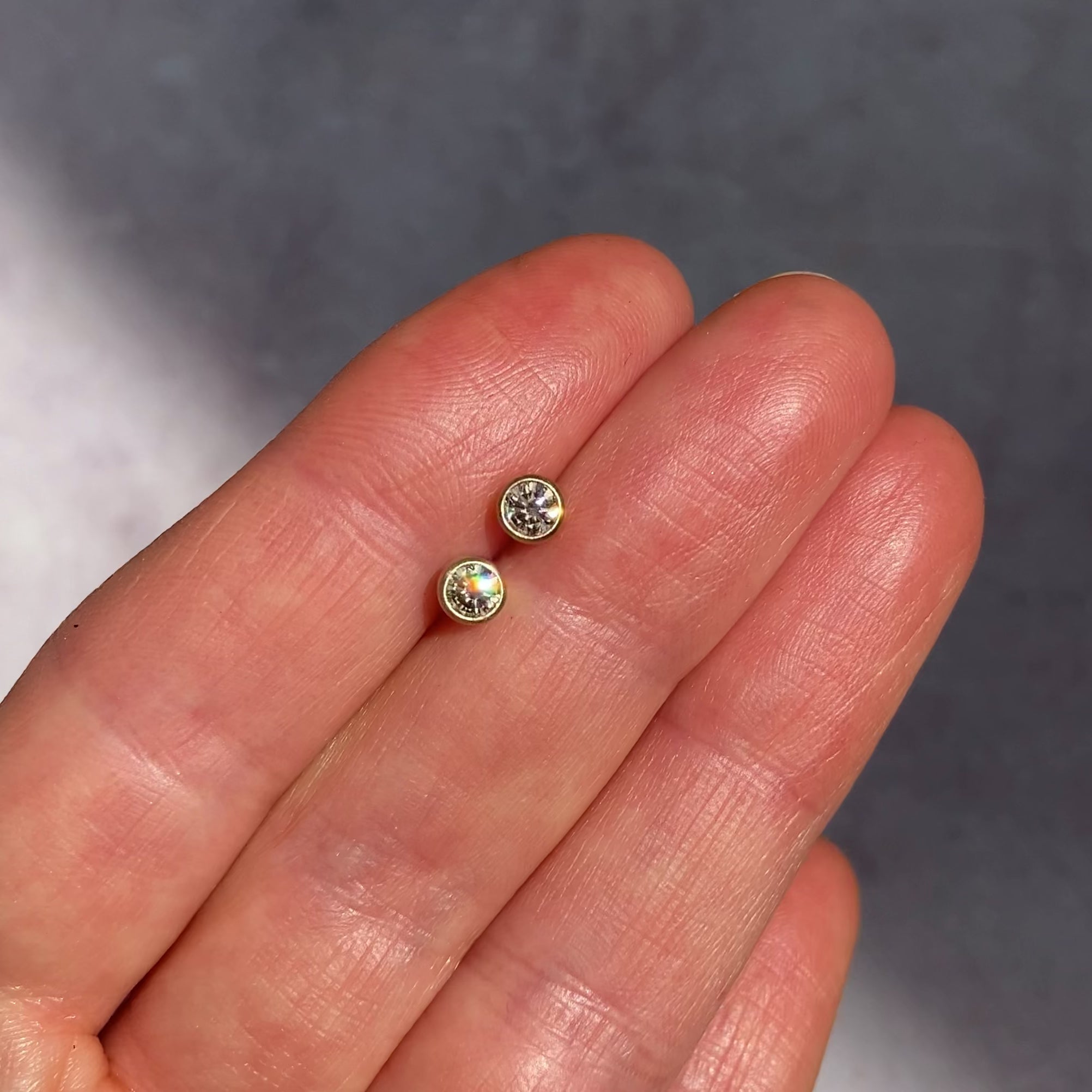 ::color_yellow ::|Champagne diamond stud earrings 0.3ctw yellow gold front view held in hand video