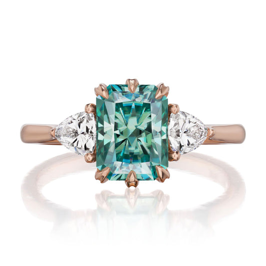 ::color_rose ::| 2.22ctw radiant aqua-teal moissanite three stone engagement ring Avery rose gold trillion diamonds front view